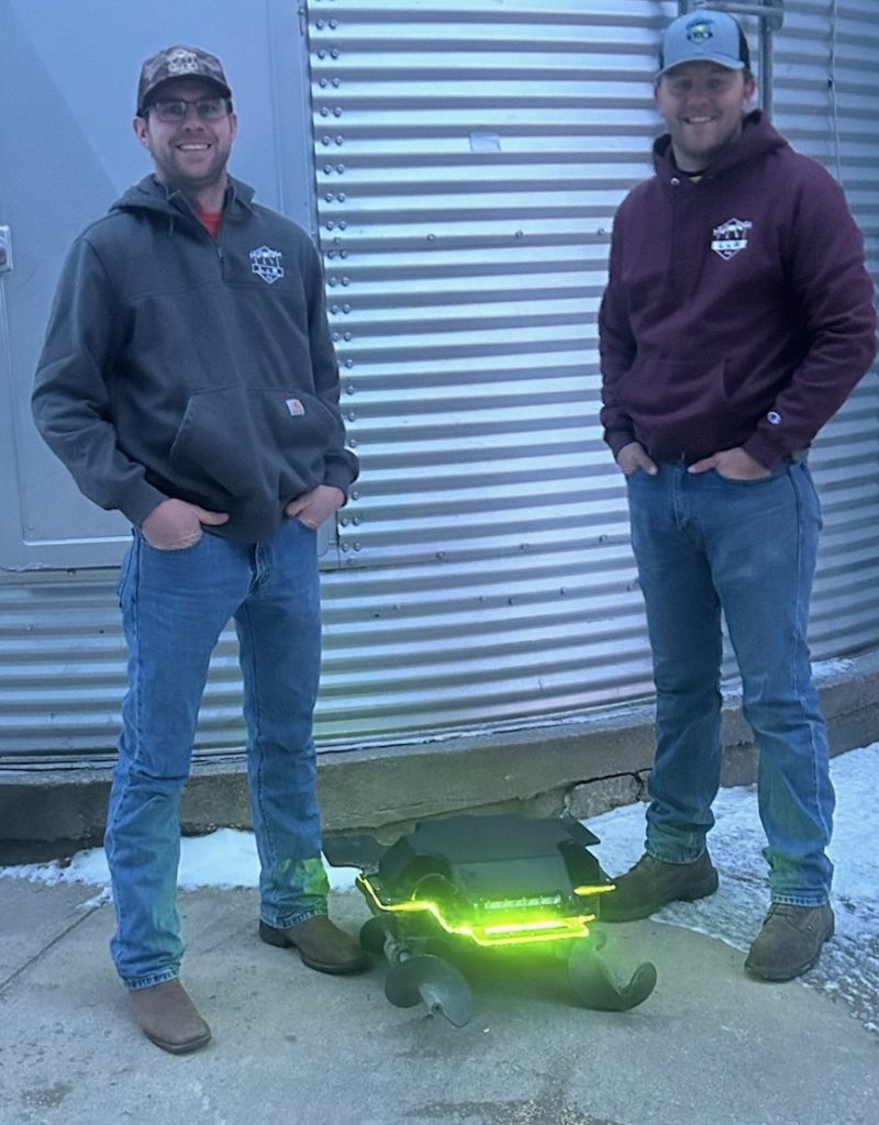 Submitted PhotoNEW TECHNOLOGY — Luke Boeckman and Ryan Vonder Haar, of L&R Ag, stand outside of a grain bin with the Grain Weevil robot.