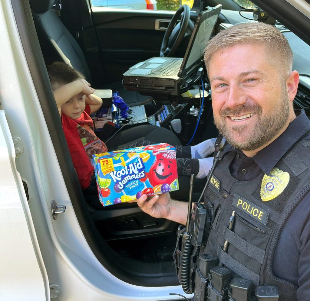 Submitted PhotoREADY FOR SCHOOL — Deputy Chief Tyler Rose with the Salem Police Department spotted a local youngster waiting to head off to preschool during a recent morning and gave him a Kool-Aid Jammers drink as part of Operation Juice Box.